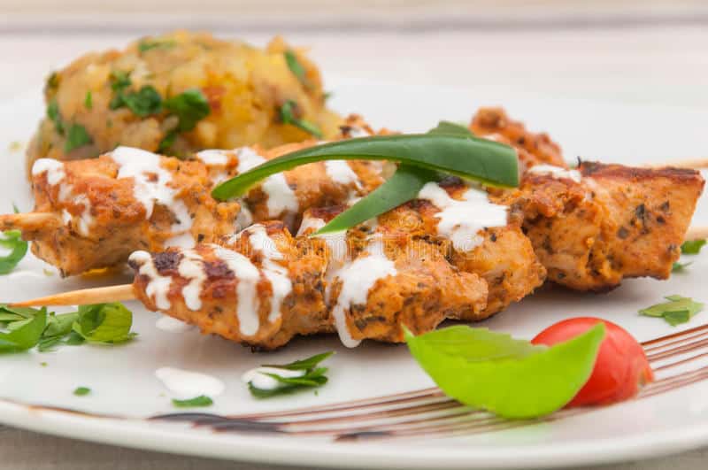 TrendMantra chicken-kebab-sour-cream-indian-cuisine-white-plate-paprika-cherry-tomato-37773611 Complete List Of Popular Must Have Food Places In Delhi! This Needs To Be Saved & Shared  